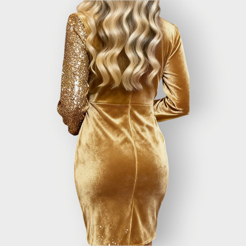 Model posing in the Abbie asymmetrical dress in gold, full-length view showing movement and drape