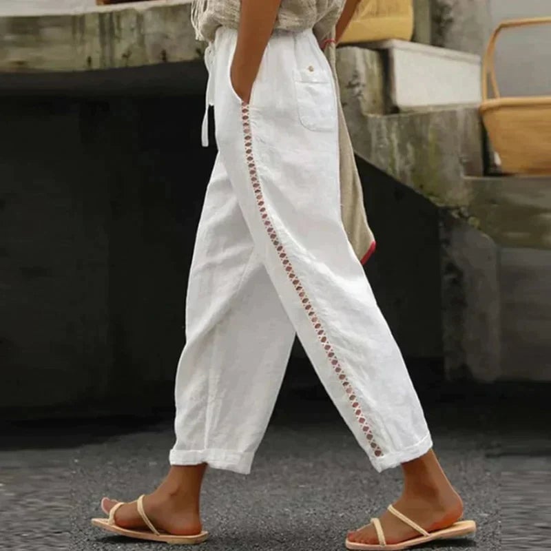Women's white high-waist tapered linen-look trousers with contrast button side stripe, front view