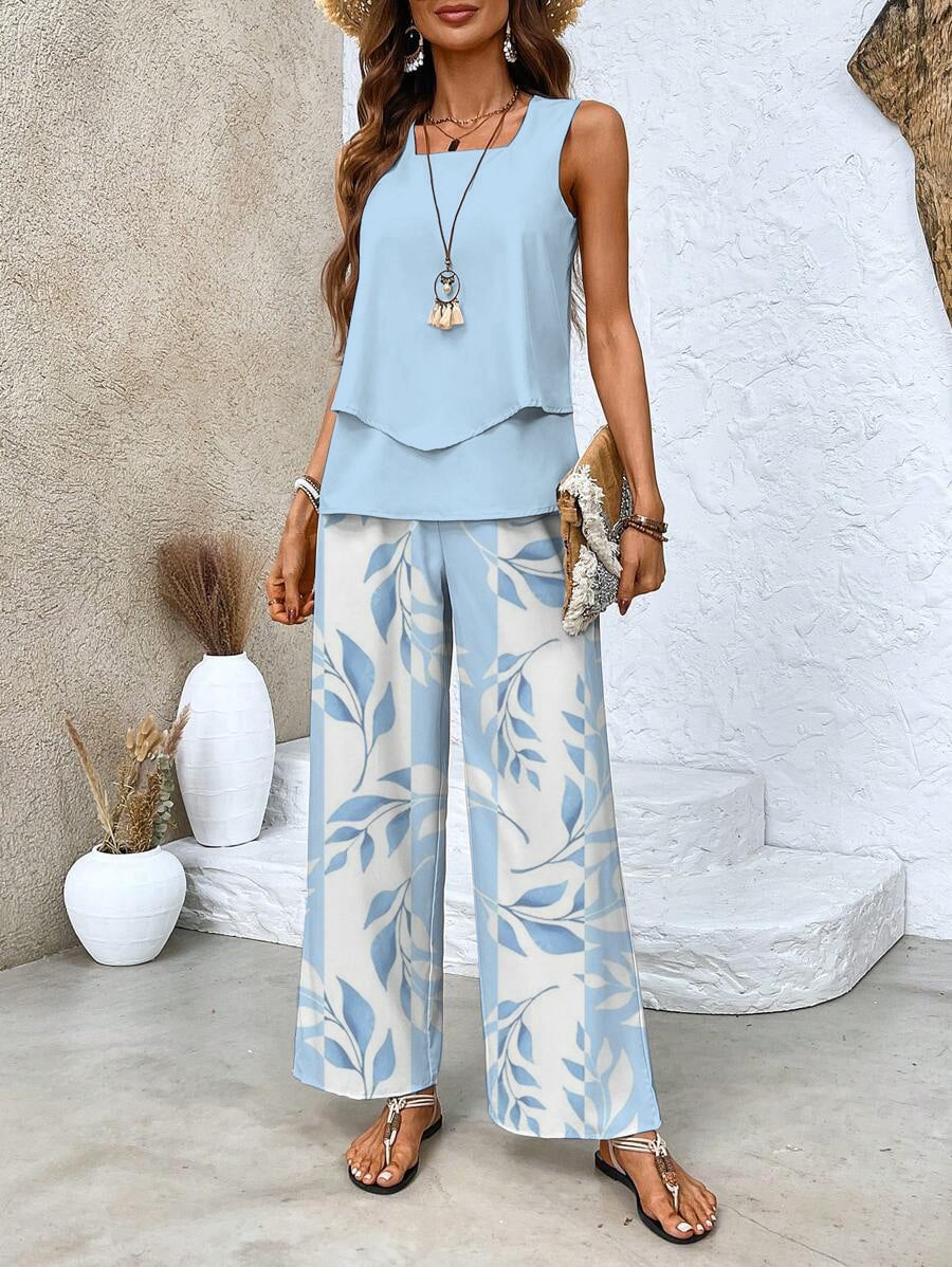 Woman wearing a chic two-piece sleeveless blouse and wide-leg pants set in blue with a leaf pattern