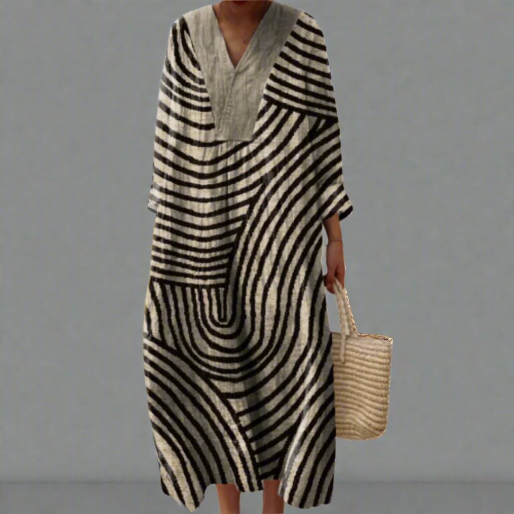 Woman wearing an elegant flowing geometric-print dress with a relaxed, flattering silhouette in a modern art-inspired pattern