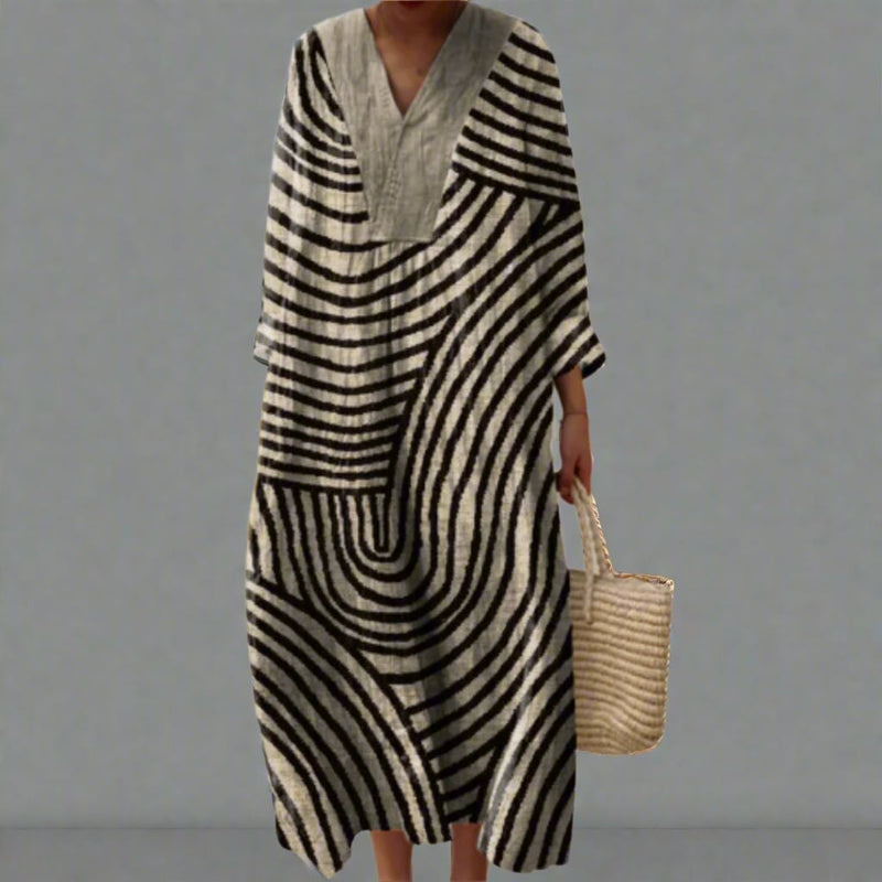 Woman wearing an elegant flowing geometric-print dress with a relaxed, flattering silhouette in a modern art-inspired pattern