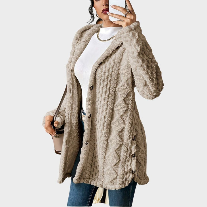 Close-up of a soft plush hooded cardigan in neutral tone showing velvety fabric texture and roomy hood detail