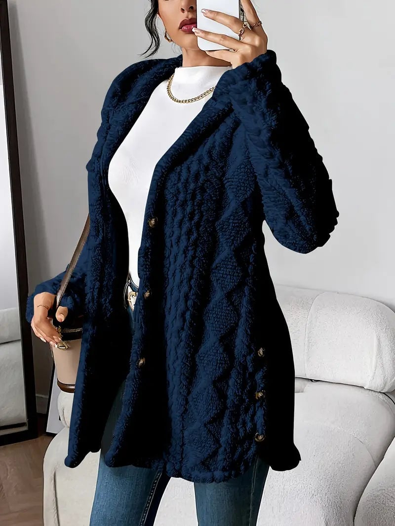 Woman in a navy blue plush hooded cardigan pulling up the hood for a cozy layered look