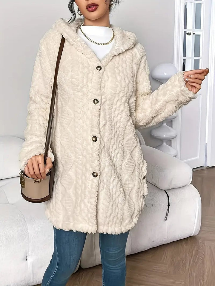 Woman wearing the Adriana cardigan in pink, smiling in a relaxed home setting