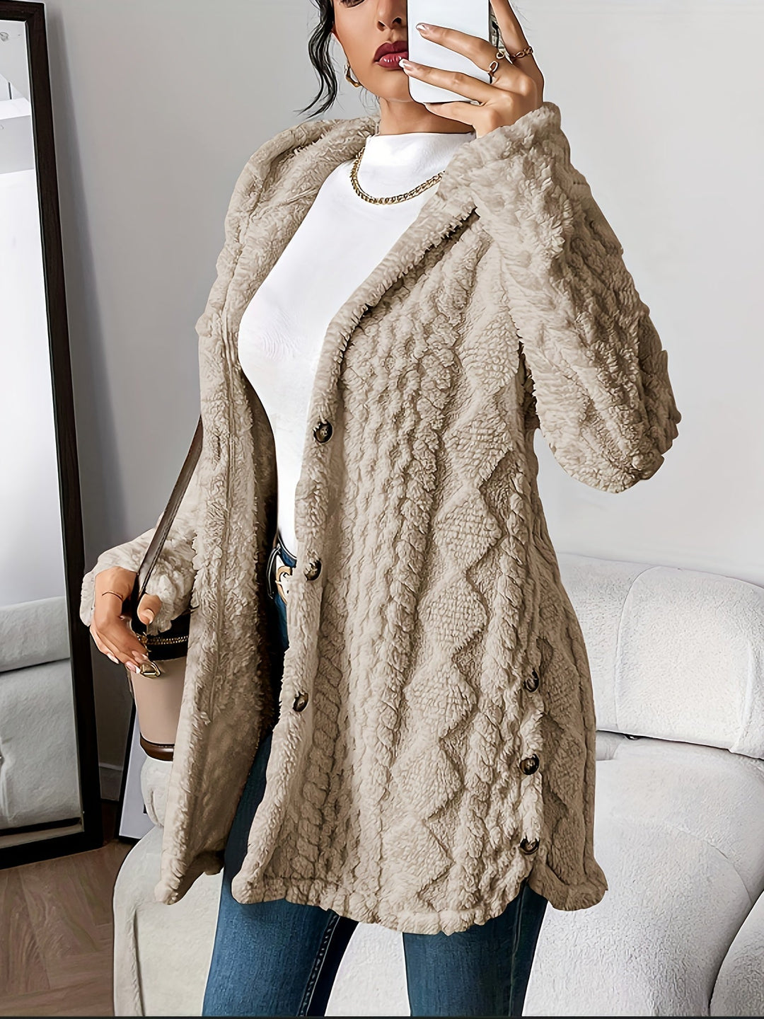 Lifestyle image of woman in a cozy plush hooded cardigan holding a warm drink on a cool morning