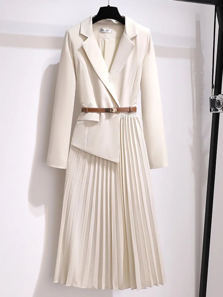 Front view of the Adrienne belted pleated midi dress in beige with blazer-style bodice and flowing pleated skirt
