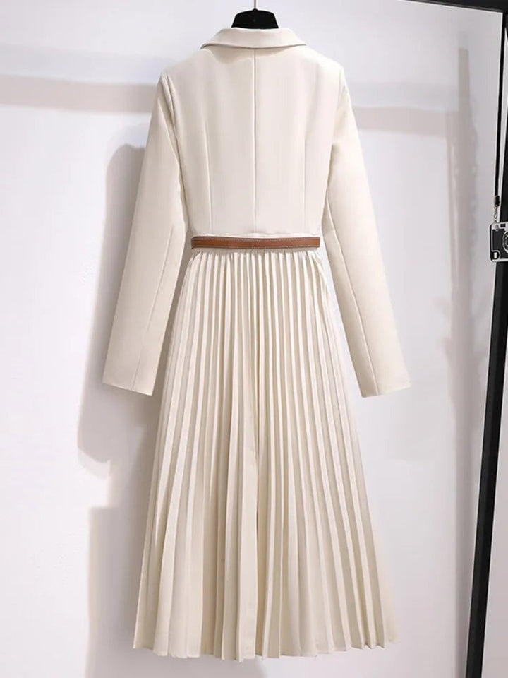 Close-up of the pleated skirt detail on the Adrienne midi dress in beige highlighting fabric movement