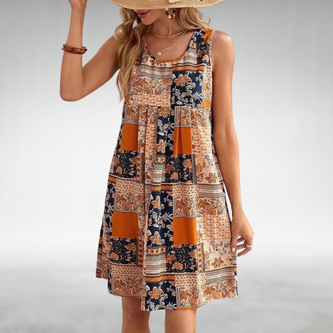Woman wearing the Ainsley boho flowy printed draped beach dress in orange, showing the full flowing silhouette