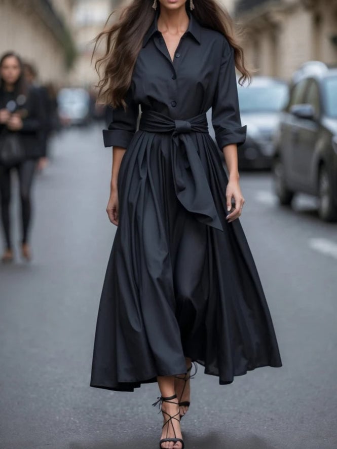 Model in a long-sleeve tie-waist maxi dress showing the full-length graceful silhouette