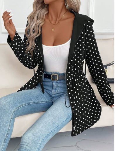 Model flipping the Aleah coat to reveal the leopard print side outdoors