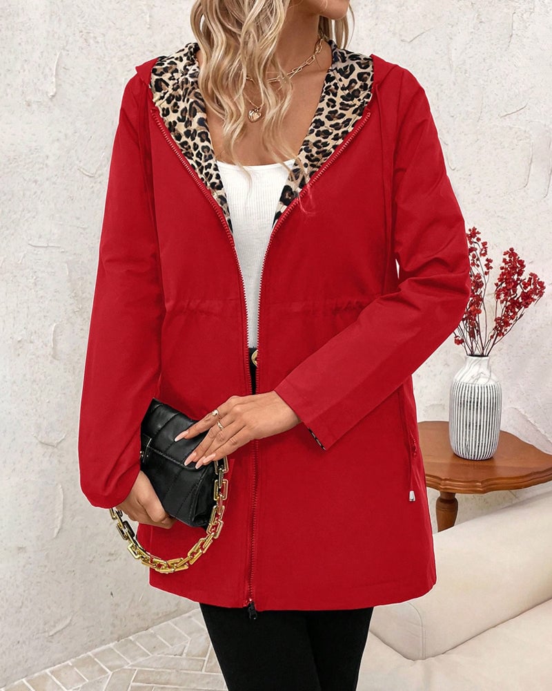 Model wearing the Aleah coat neutral side in red over a dress for an elevated evening look