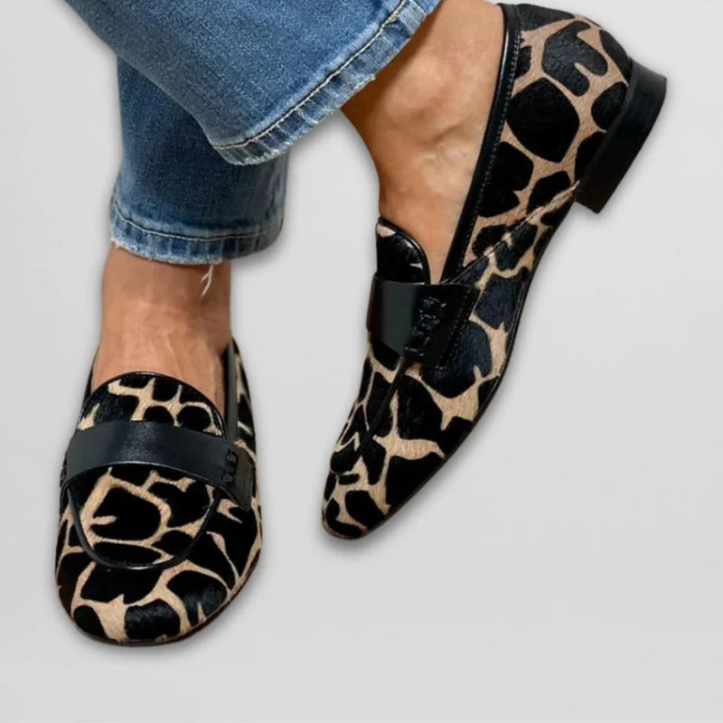 Close-up of cow print loafer upper showing soft material and bold black-and-white pattern