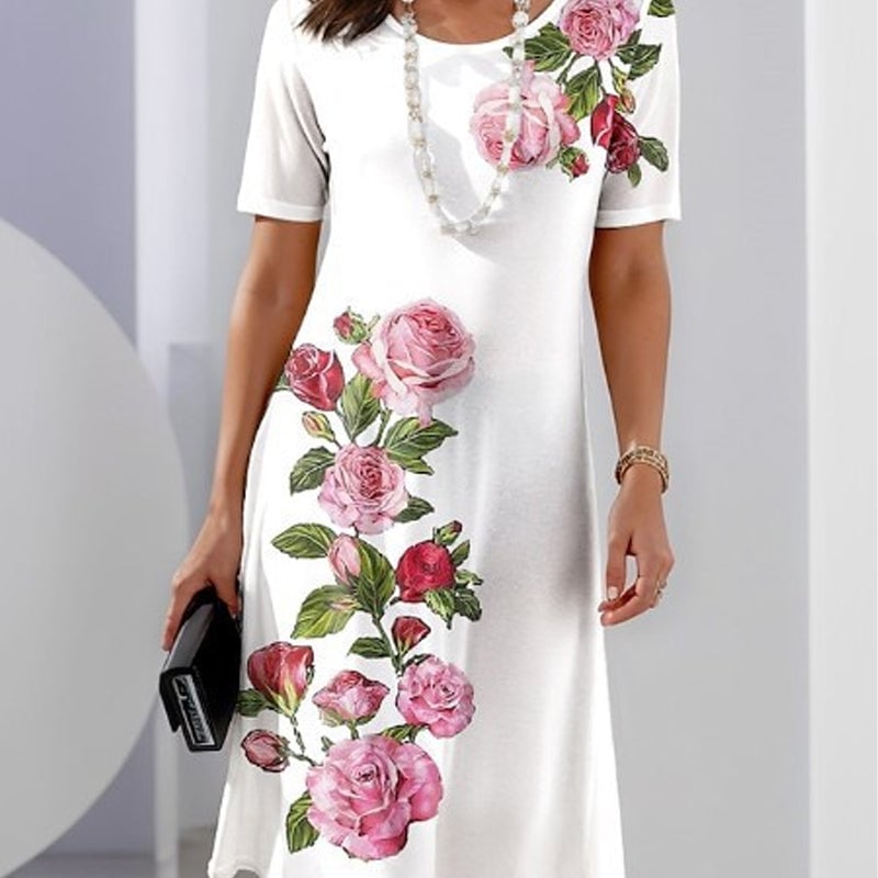 Woman wearing a black floral A-line knee-length dress, smiling in a sunny outdoor setting