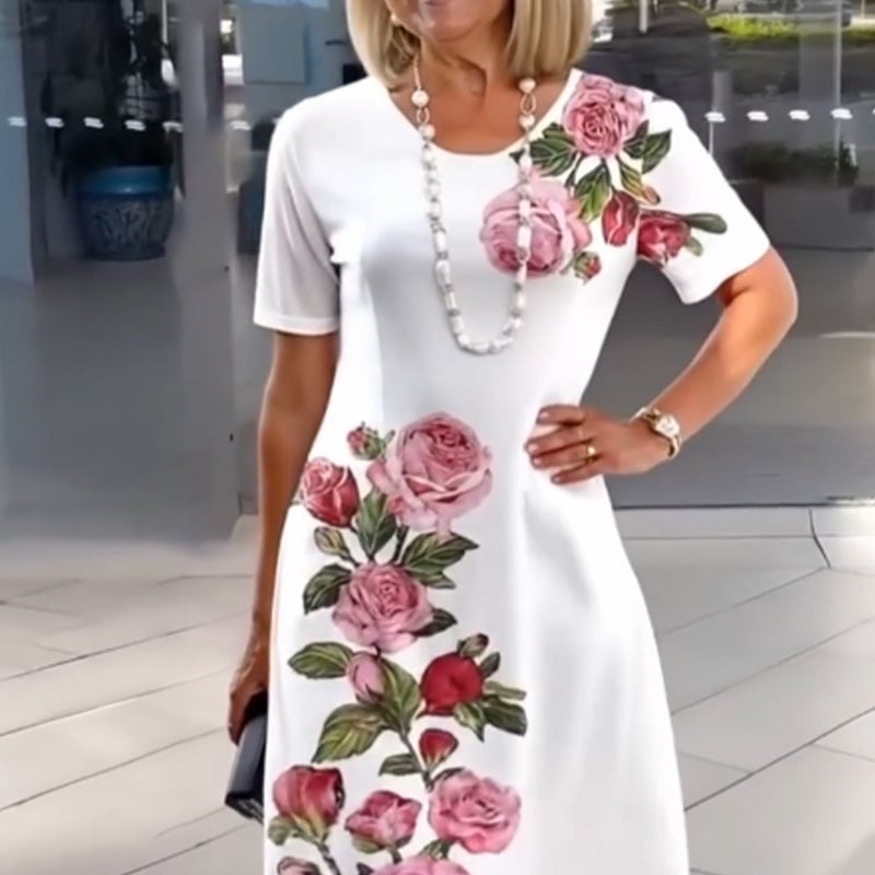 Woman in a white floral knee-length dress styled with sandals at a garden party