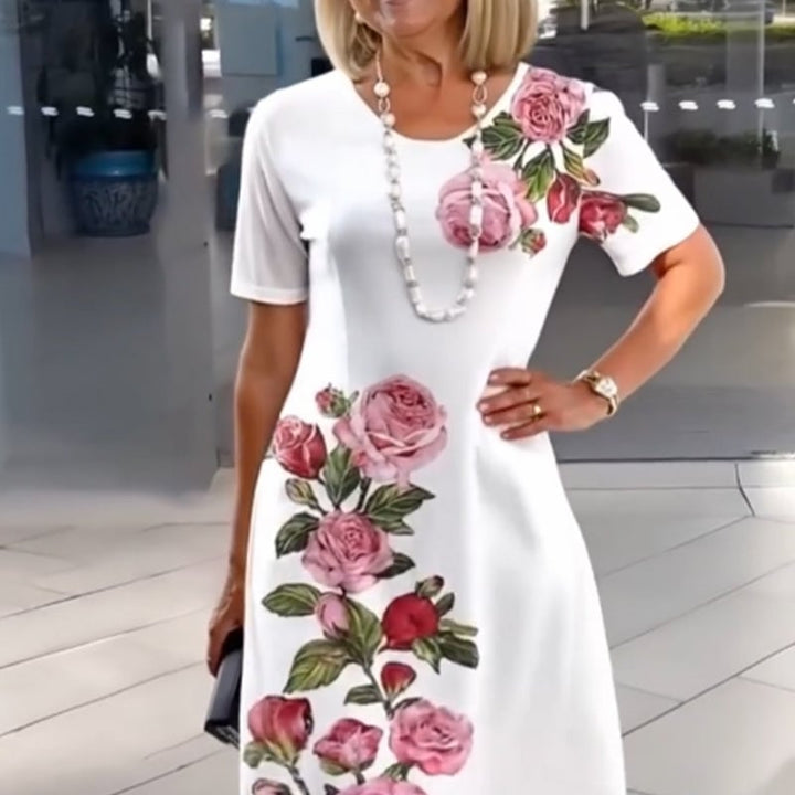 Woman in a white floral knee-length dress styled with sandals at a garden party