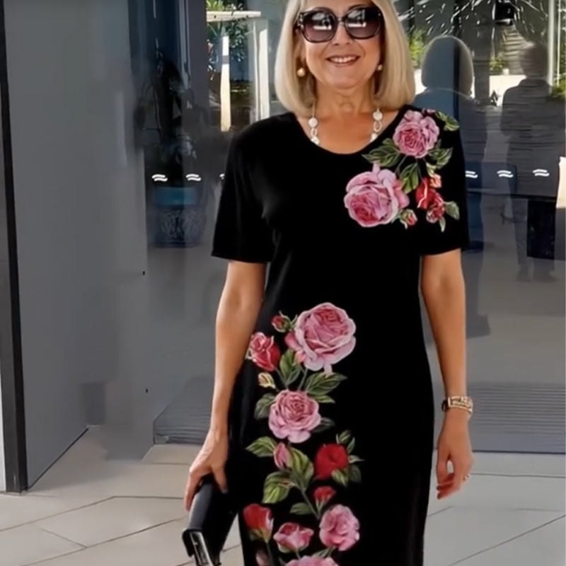 Woman smiling in a black floral dress, styled casually for a summer day out