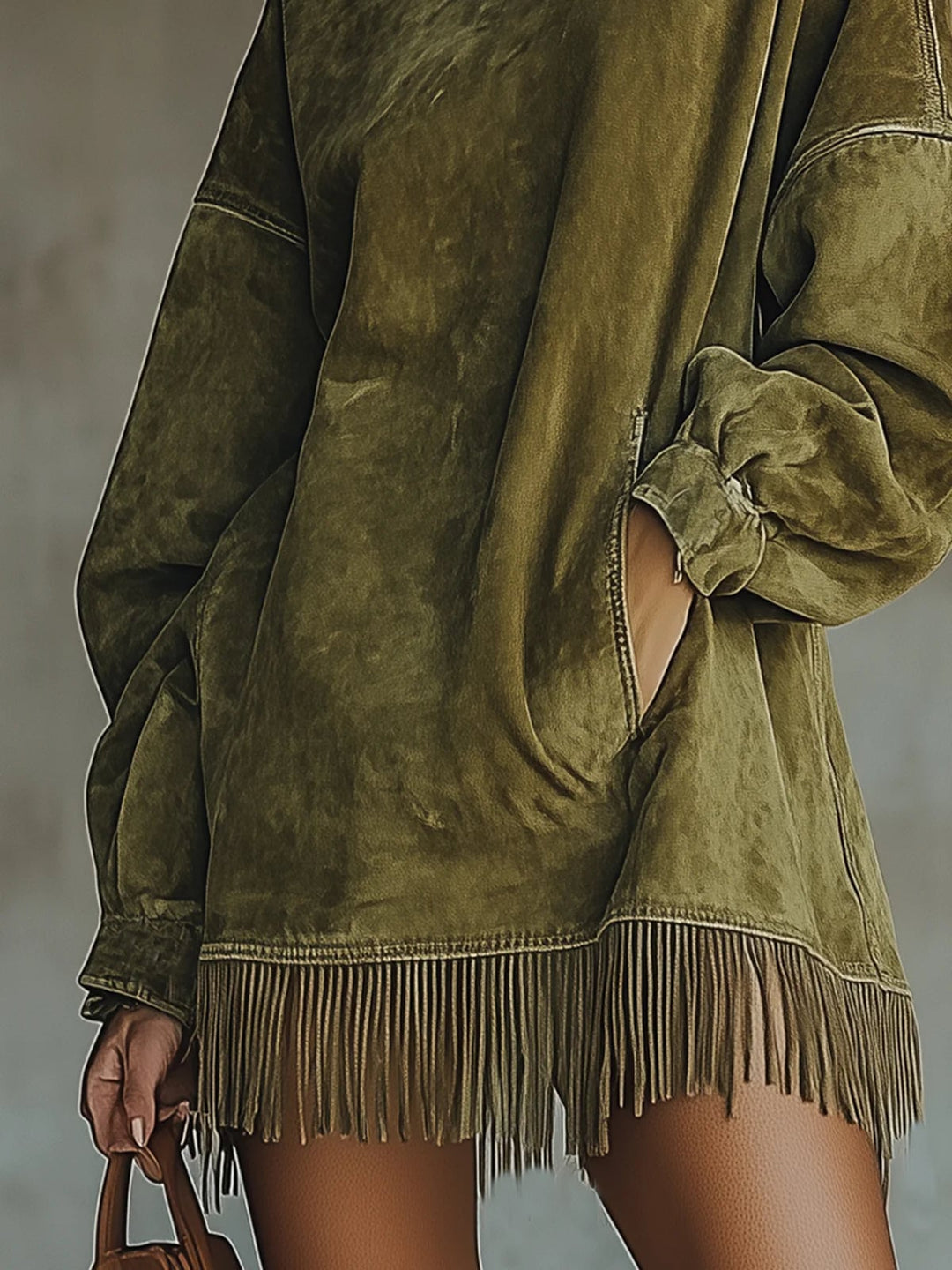 Detail shot of soft suede-like fabric texture and delicate fringe trim on cozy dress