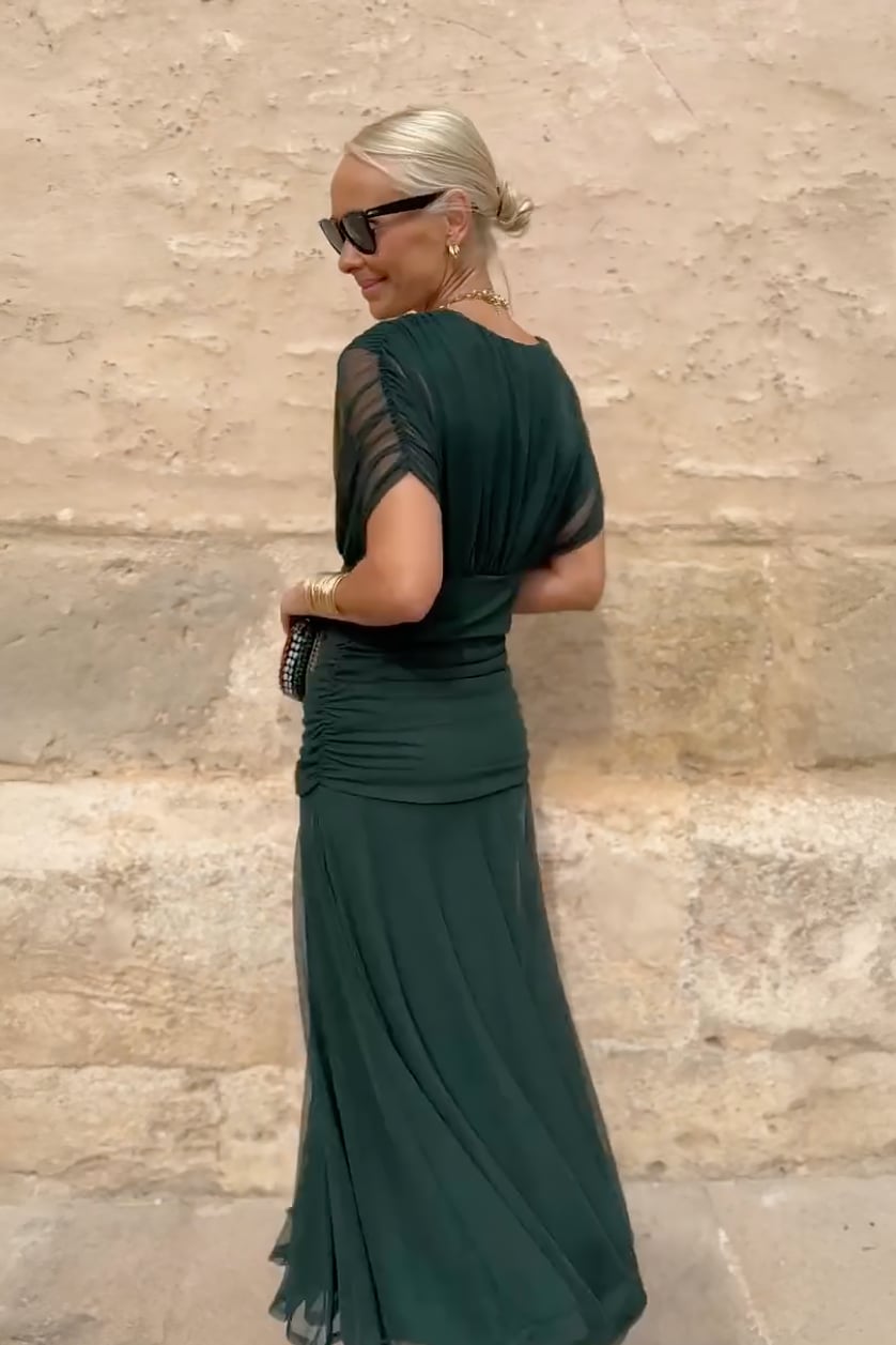 Detail shot of the V-neckline on a green flowing maxi dress