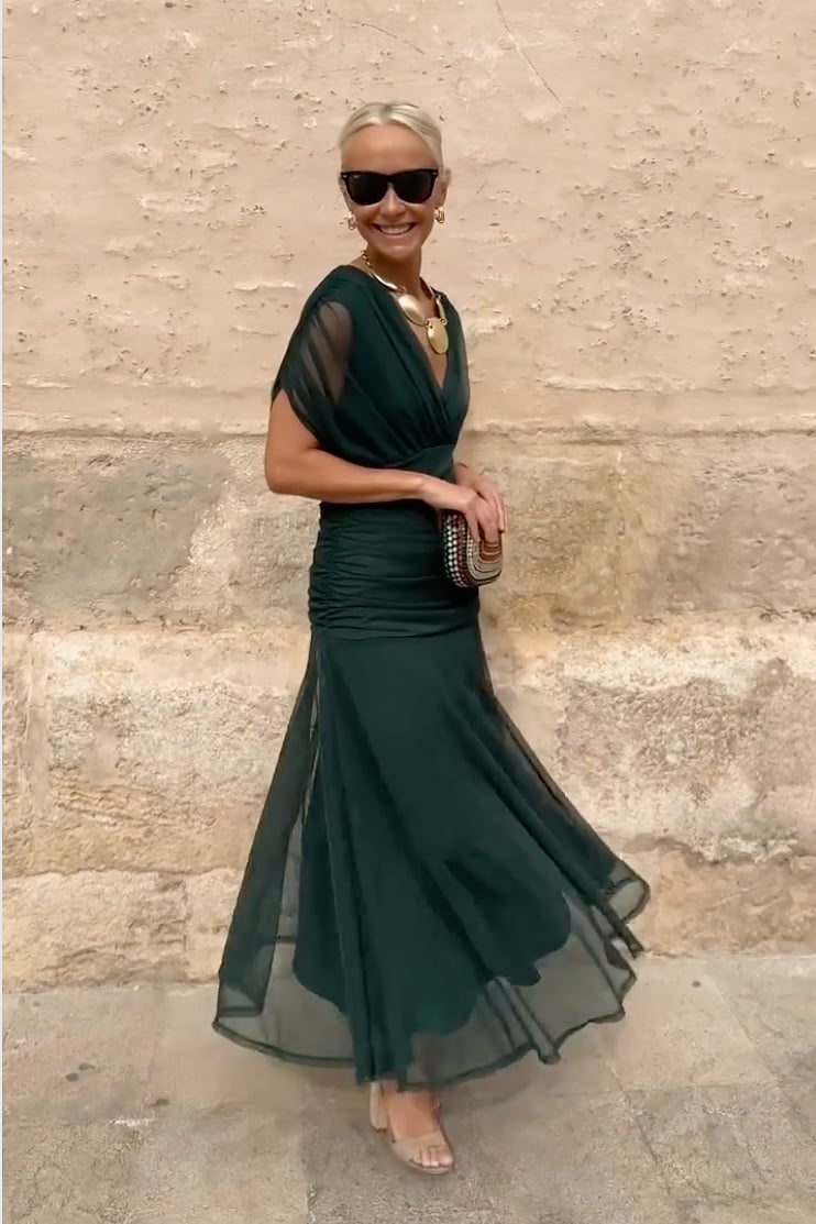 Model wearing a green fantasy maxi dress showing movement in the skirt