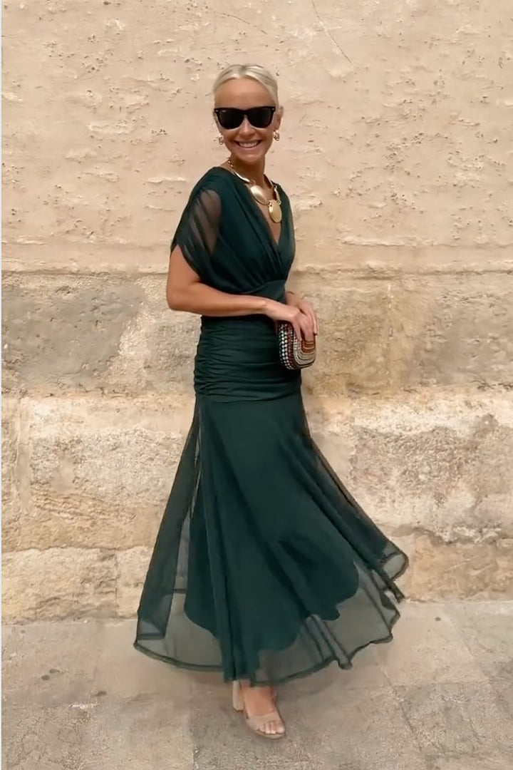 Model wearing a green fantasy maxi dress showing movement in the skirt