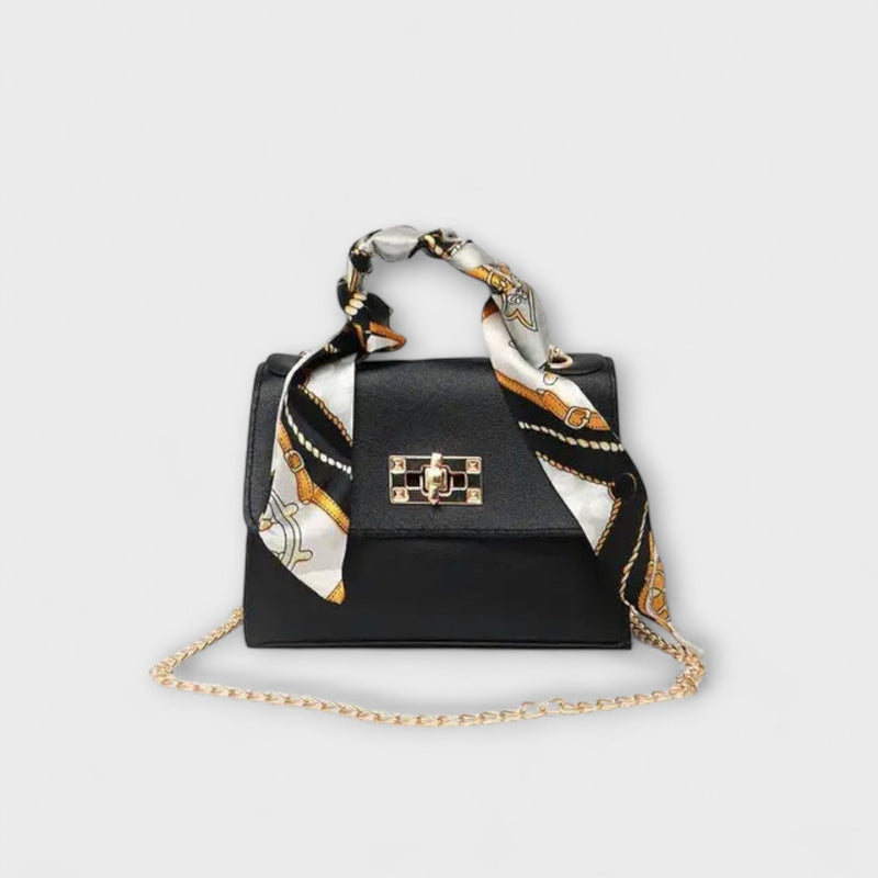 Black elegant structured handbag with embossed decorative hand strap and removable chain strap