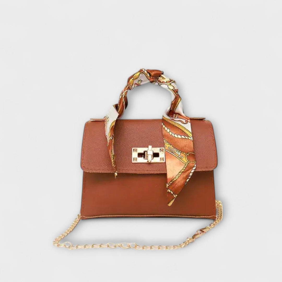 Pink structured elegant handbag with embossed strap and removable gold-tone chain
