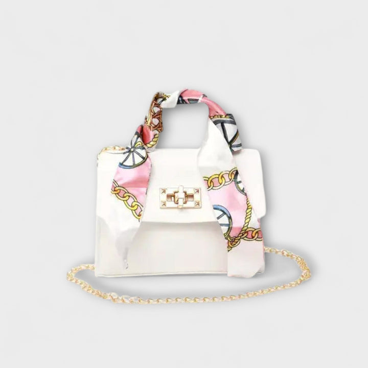Close-up of embossed decorative hand strap detail on elegant structured handbag