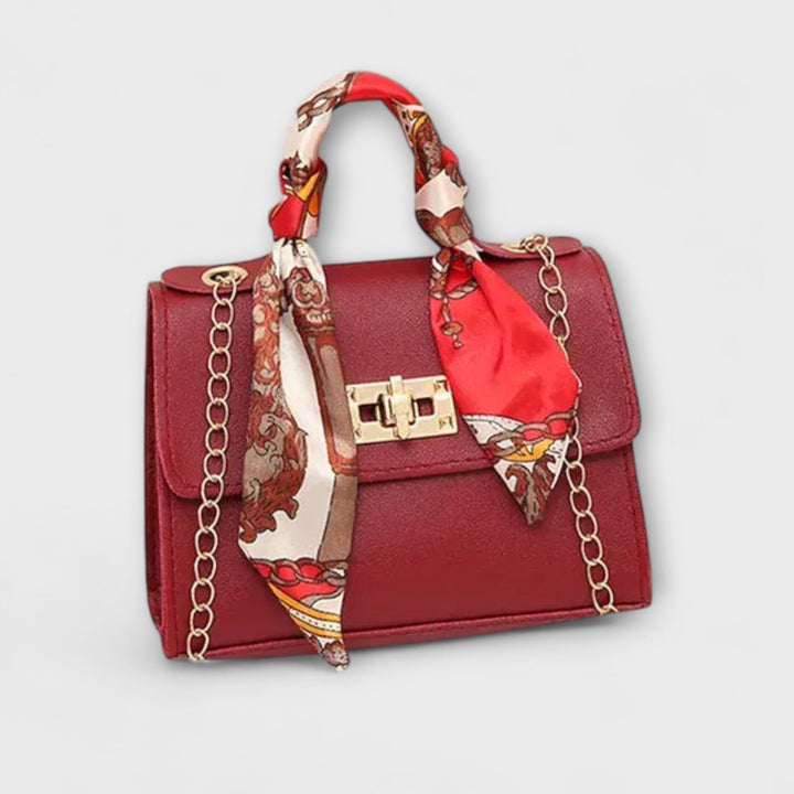 Flat lay of elegant handbag with removable chain strap shown alongside bag body