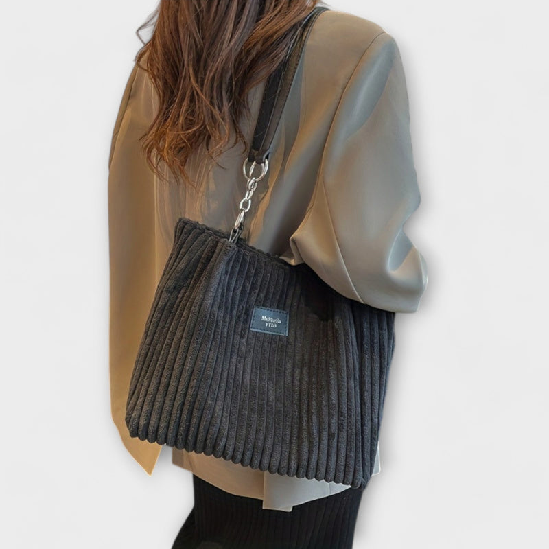 Close-up of ribbed detailing and metal chain accent on the Alvinda shoulder bag in beige