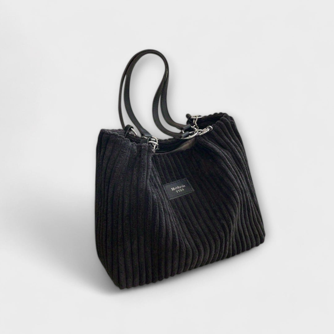 Side view of the Alvinda shoulder bag showing spacious silhouette and chain hardware