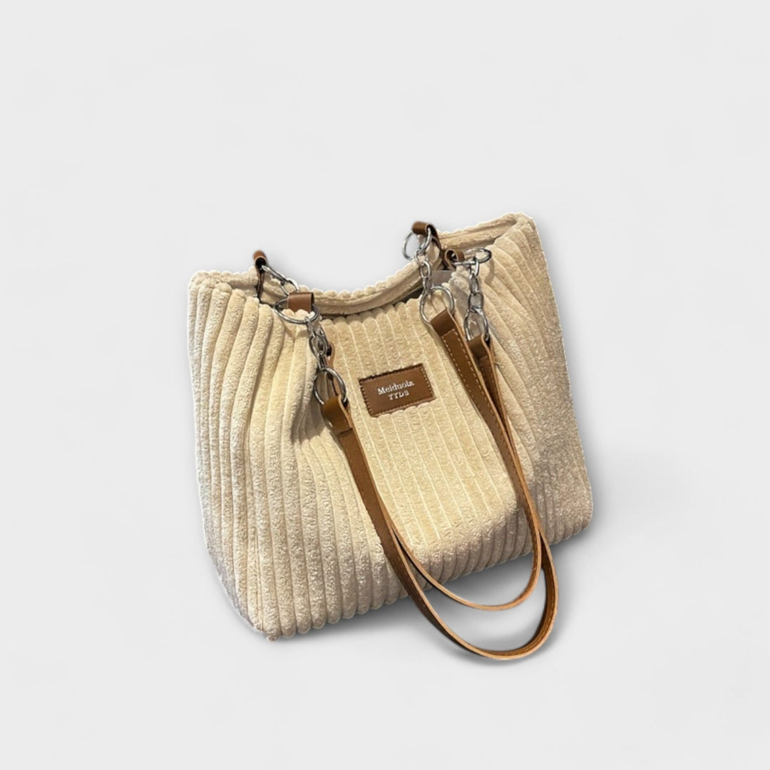 Lifestyle flat lay of the Alvinda shoulder bag styled with everyday accessories