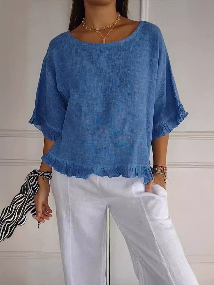 Front view of the Amanda ruffle blouse in blue showing minimalist cut and feminine hem ruffles