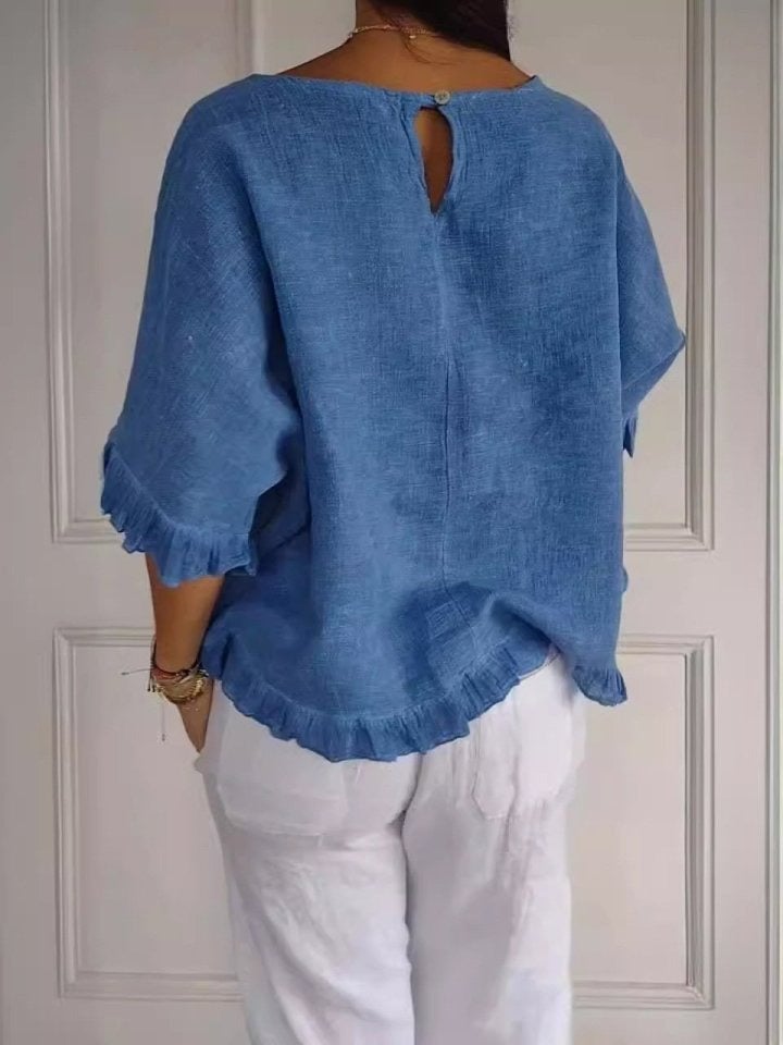 Woman in a casual elegant ruffle blouse paired with jeans, showing versatile everyday styling