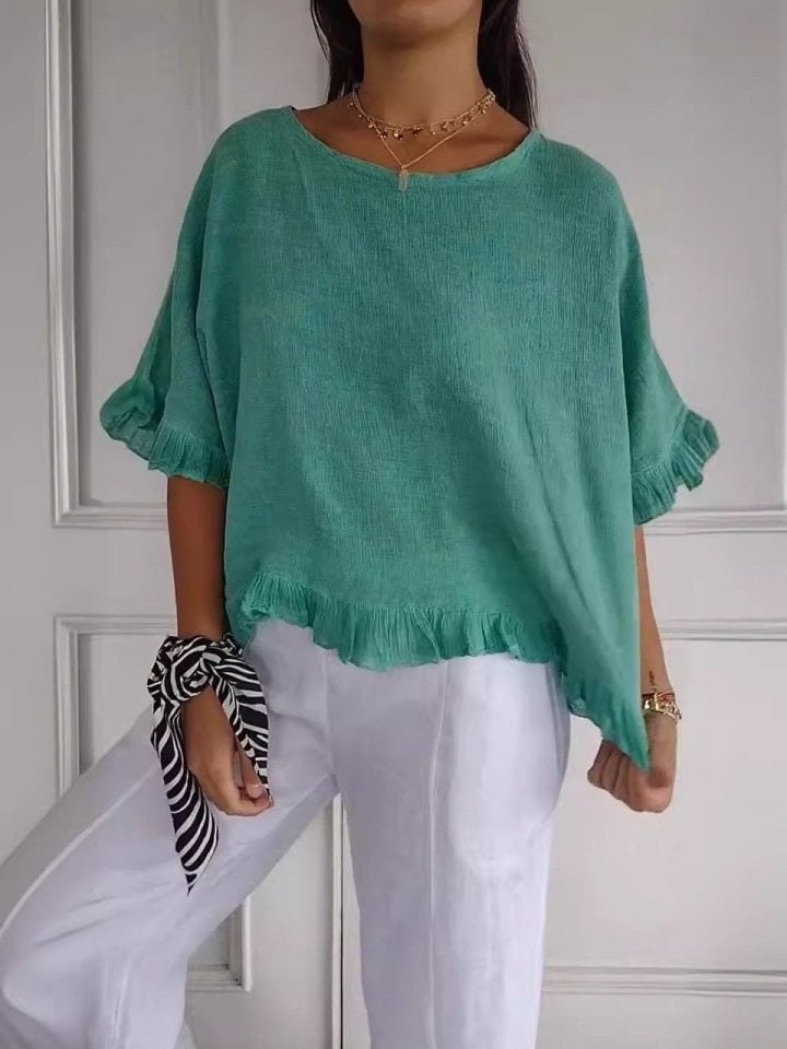 Amanda blouse in green colorway displayed on model, highlighting airy fabric and graceful silhouette