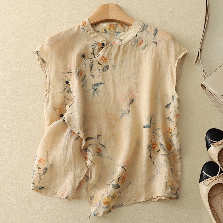Woman wearing a flowy floral sleeveless top with a mandarin collar and slanted button closure in a dark base print