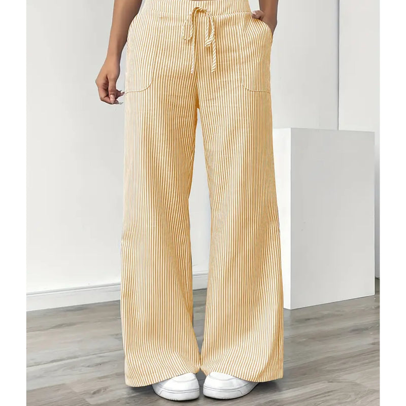 Woman wearing yellow striped pants with pockets and adjustable drawstring waistband, front view