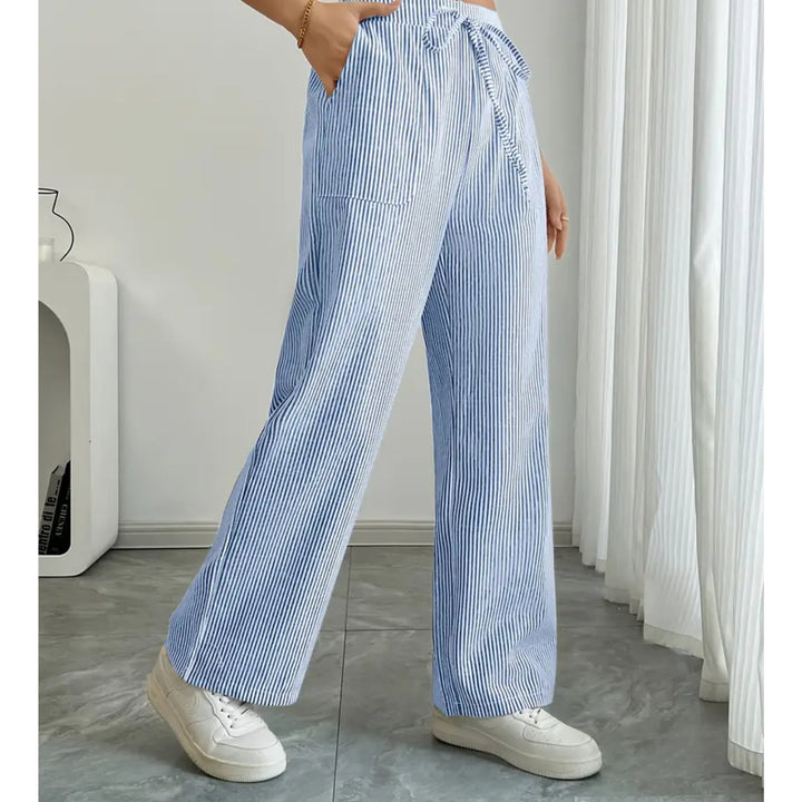 Woman wearing blue striped pants, full-length view showing leg-elongating stripe pattern