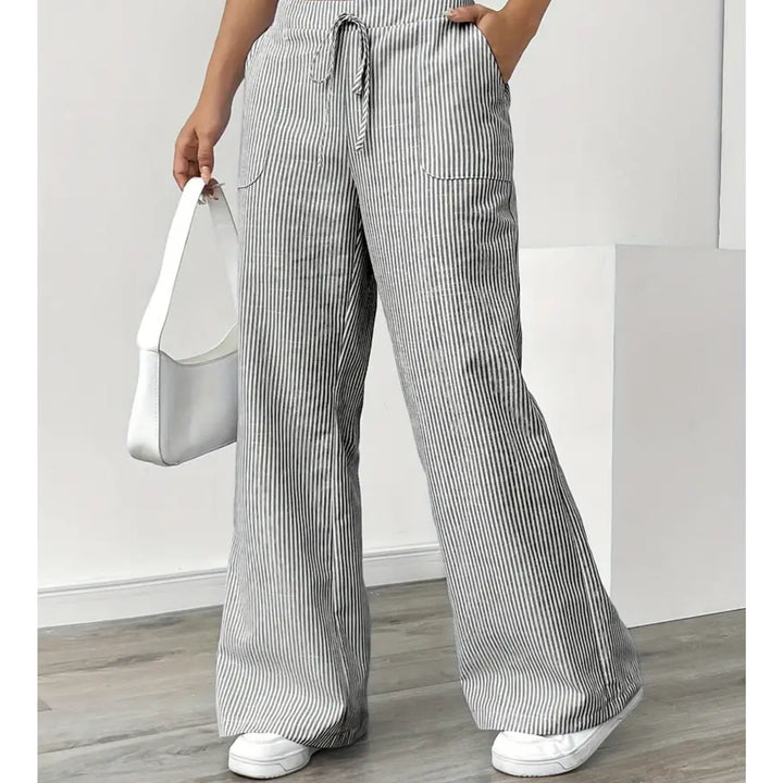 Woman in yellow striped pants walking outdoors, showcasing breathable lightweight fabric