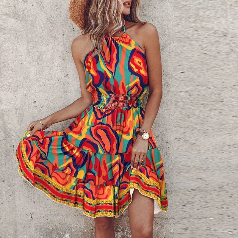 Woman wearing the Amber halter lace dress in orange, smiling and posed in natural light