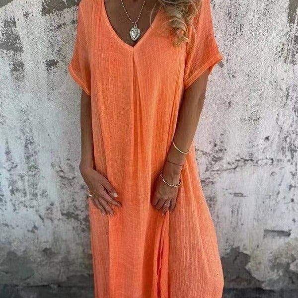 Full-length view of a model wearing a loose V-neck dress in green with sandals