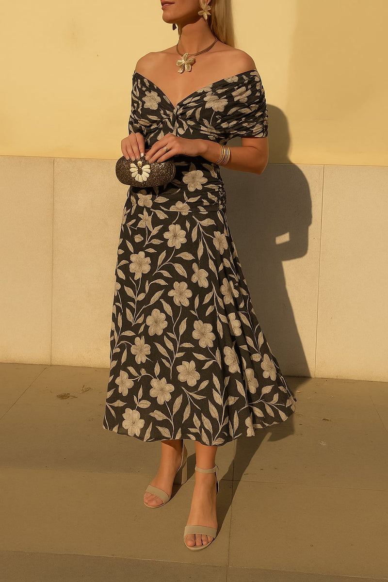 Model wearing a black off-shoulder floral midi dress with a flowing silhouette, front view