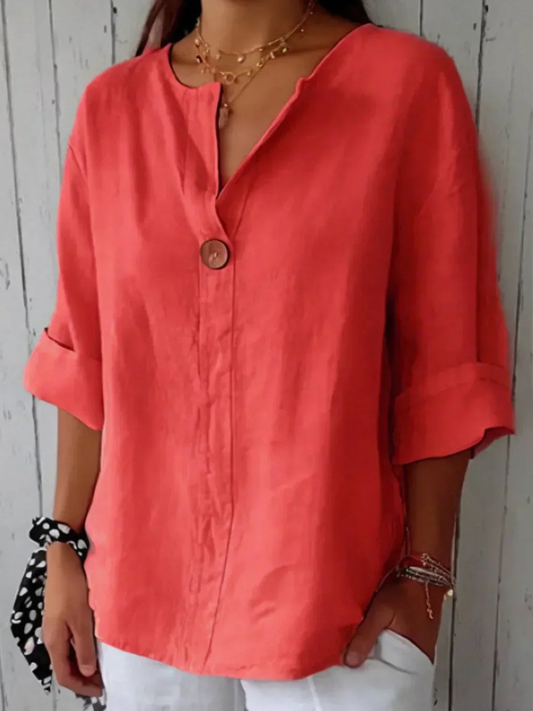 Close-up of the minimalist single-button detail on the Angela V-neck blouse in black