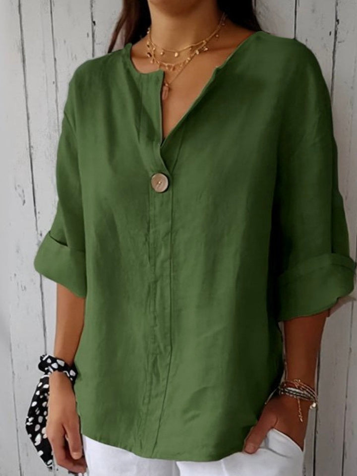 Flat lay of the Angela casual V-neck blouse in green showing the clean minimalist design