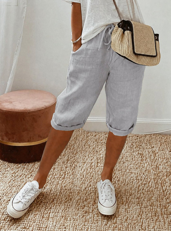 Close-up of adjustable drawstring waistband on relaxed capri pants in dark gray