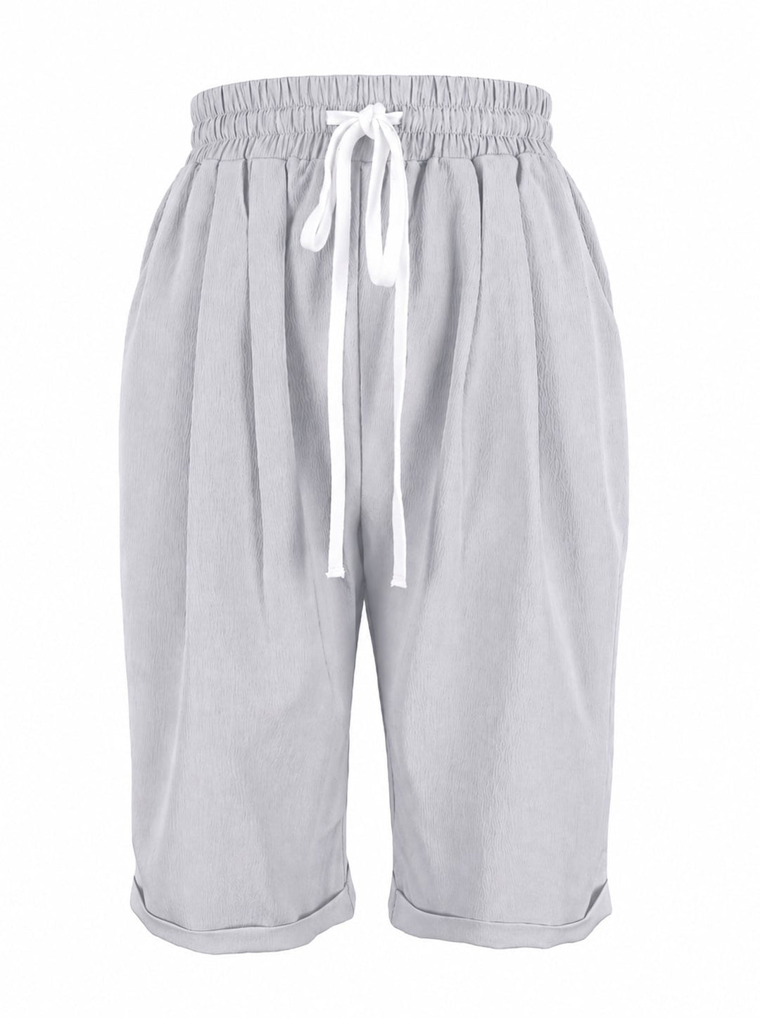 Woman styling dark gray capri pants with white sneakers and a relaxed tee