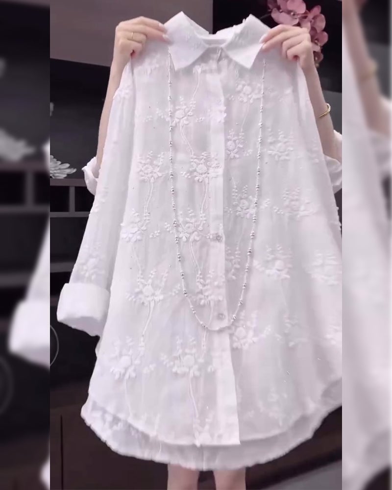 Close-up of delicate floral embroidery detail on a white dropped-shoulder shirt