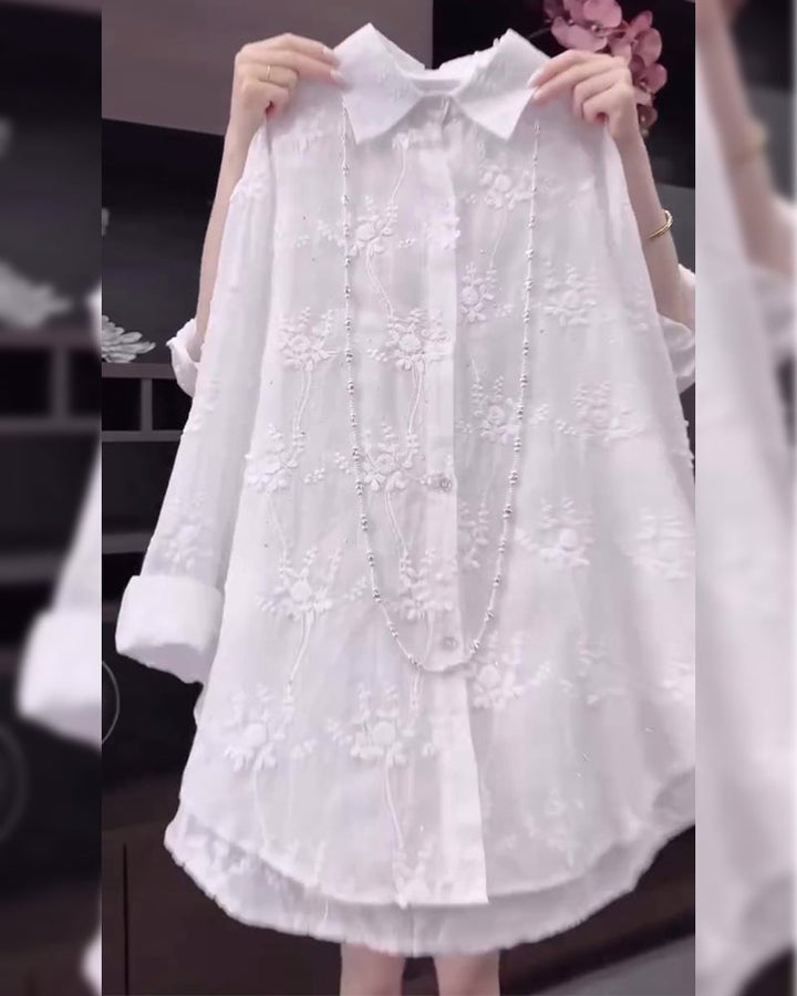 Close-up of delicate floral embroidery detail on a white dropped-shoulder shirt