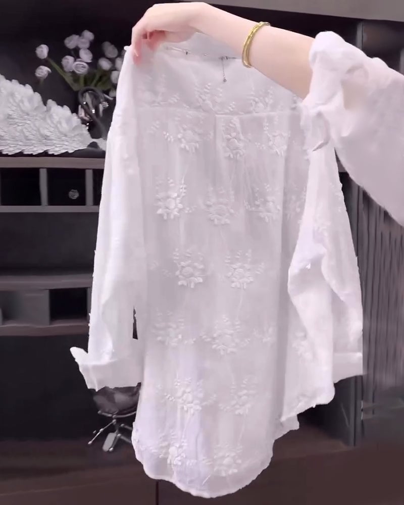 Model styling a white embroidered dropped-shoulder shirt with casual bottoms