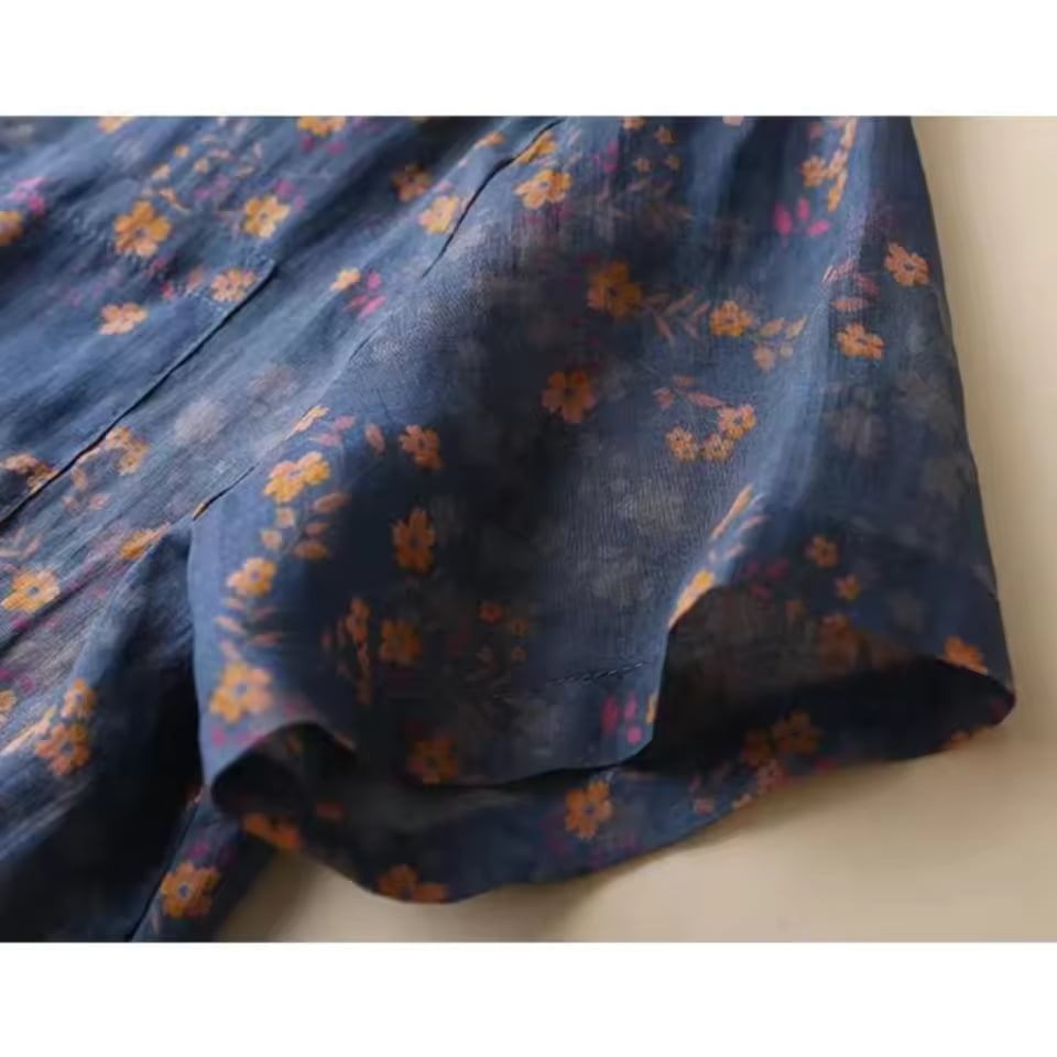 Flat lay of the floral half-placket shirt in blue showing the full silhouette and sleeve length