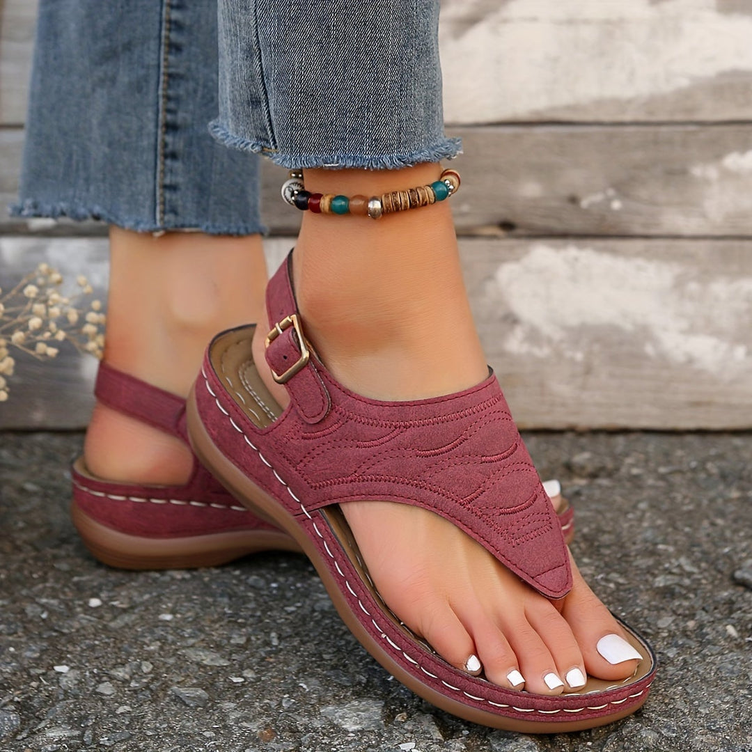 Close-up of Annette clip-toe detail in burgundy on a wooden surface